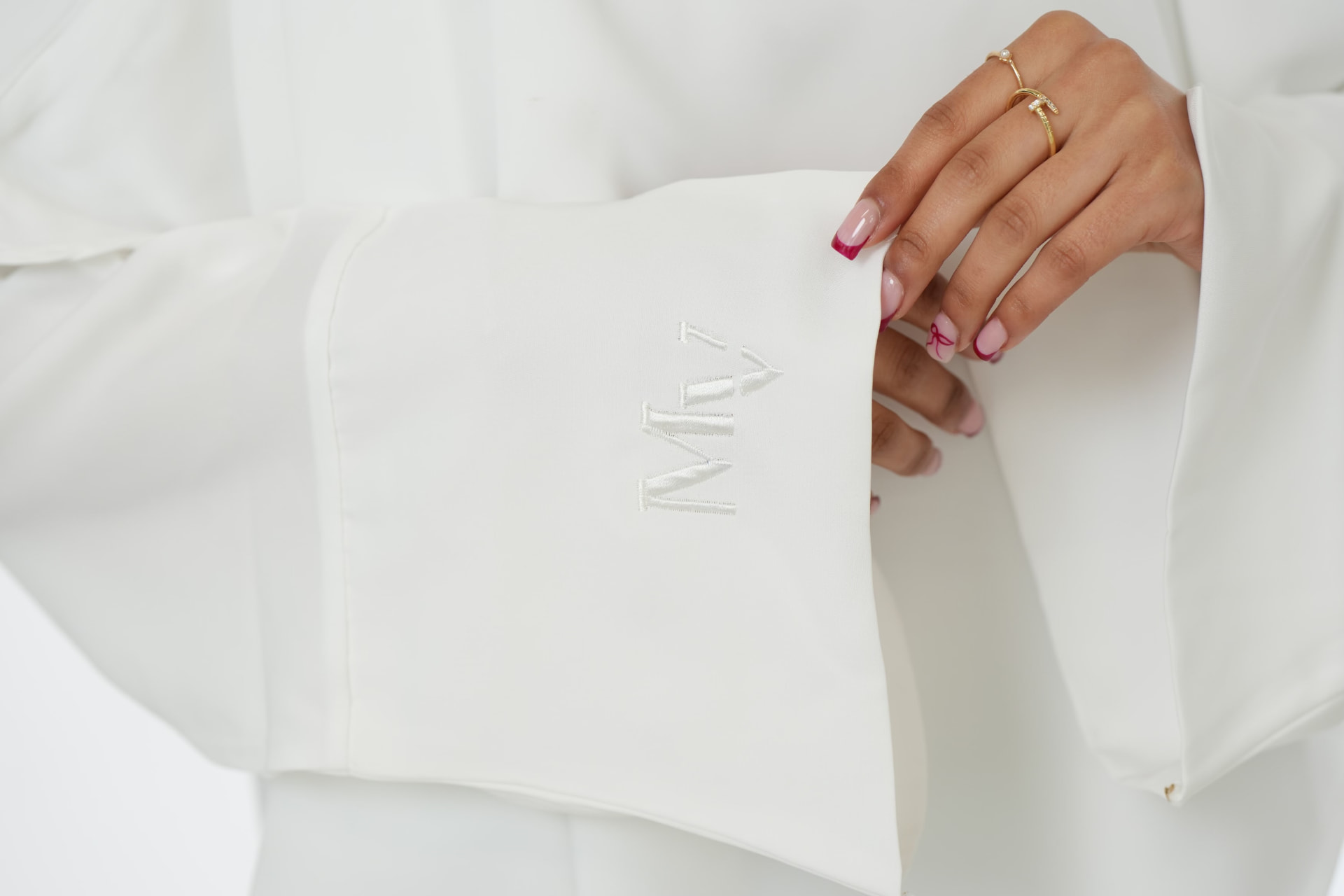 Detail shot of the MV monogram embroidered on a white sleeve.