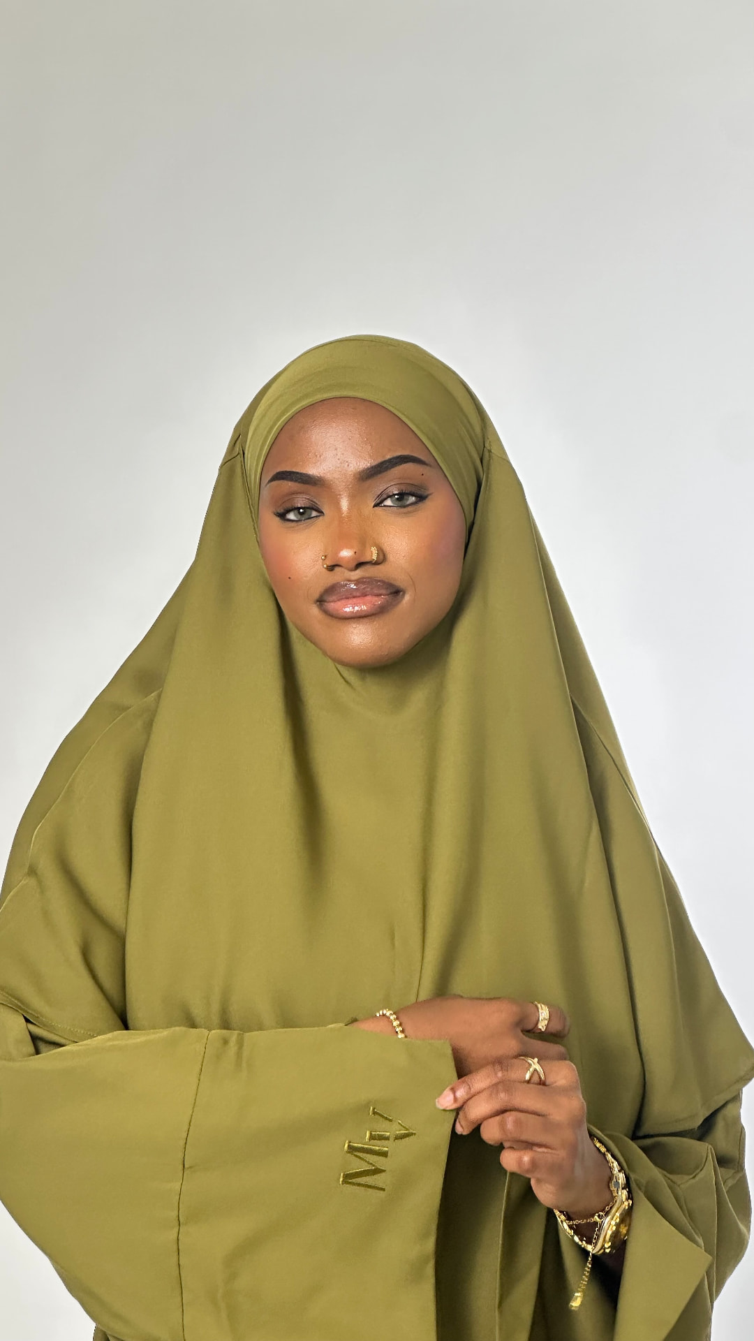 The Modesty Vault — olive jilbab portrait with embroidered sleeve detail.